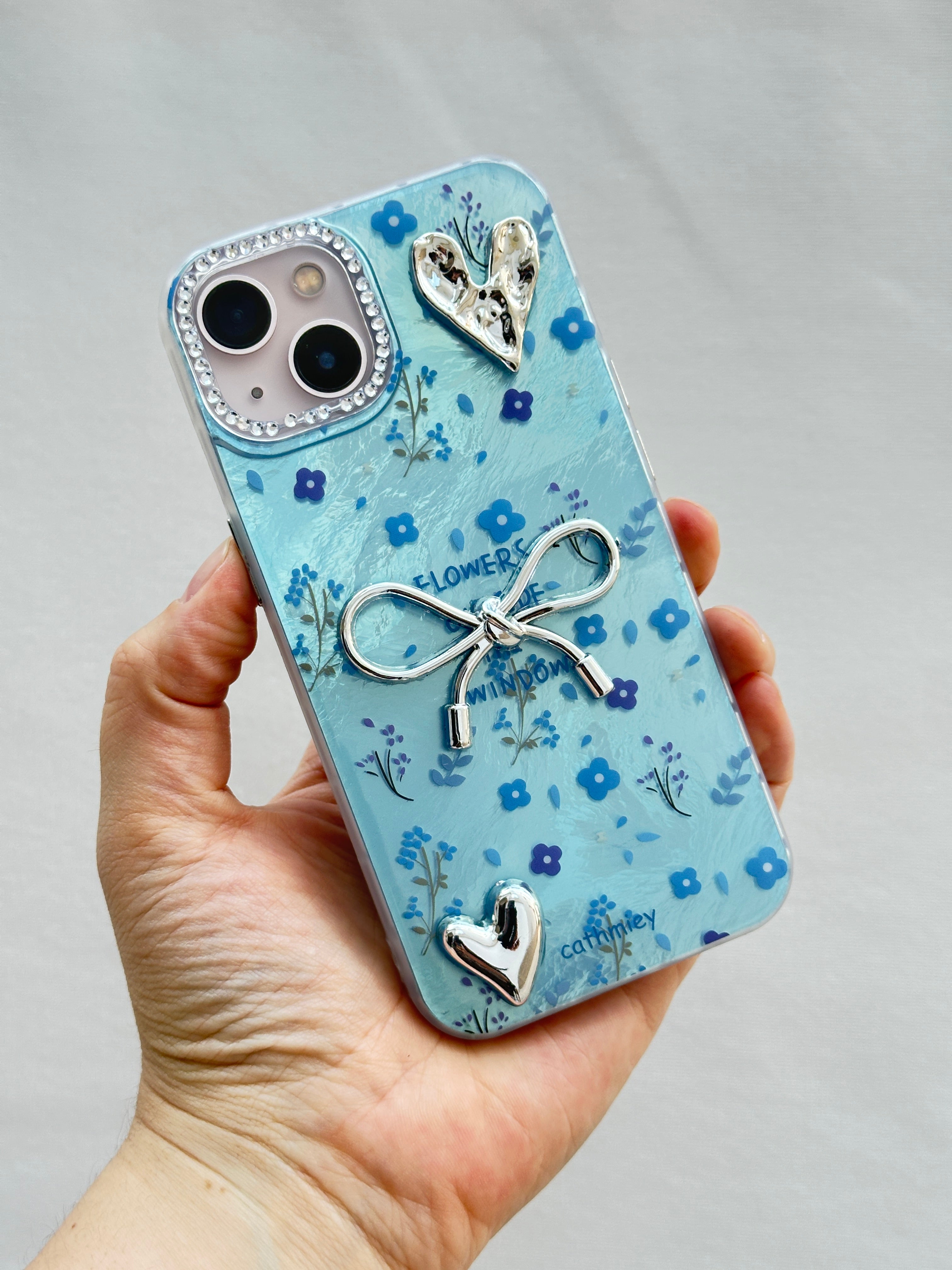 iPhone 15 Kurdelalı Kalpli Şeffaf Çiçekli Kılıf 3 Boyutlu Metalik Süslemeli Telefon Kılıfı