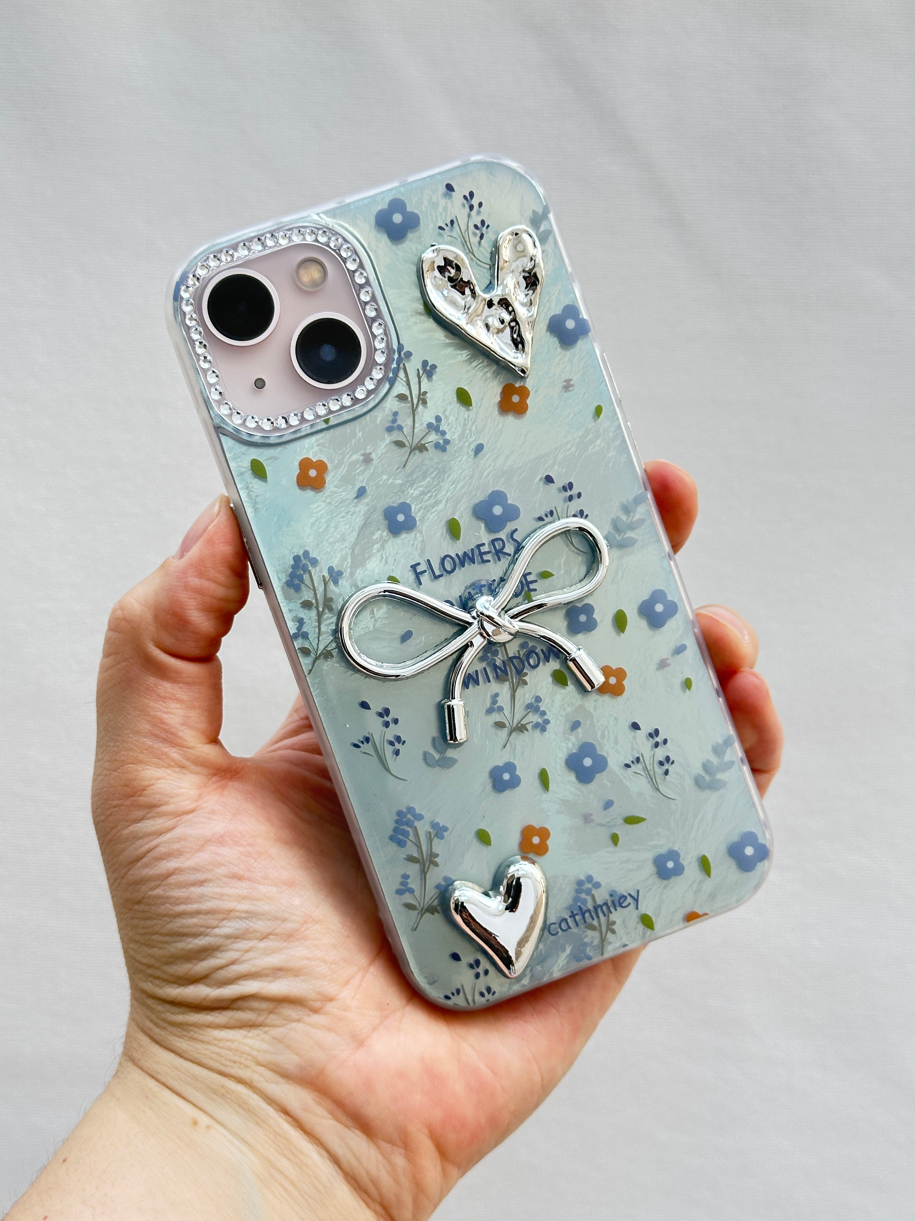 iPhone 15 Kurdelalı Kalpli Şeffaf Çiçekli Kılıf 3 Boyutlu Metalik Süslemeli Telefon Kılıfı